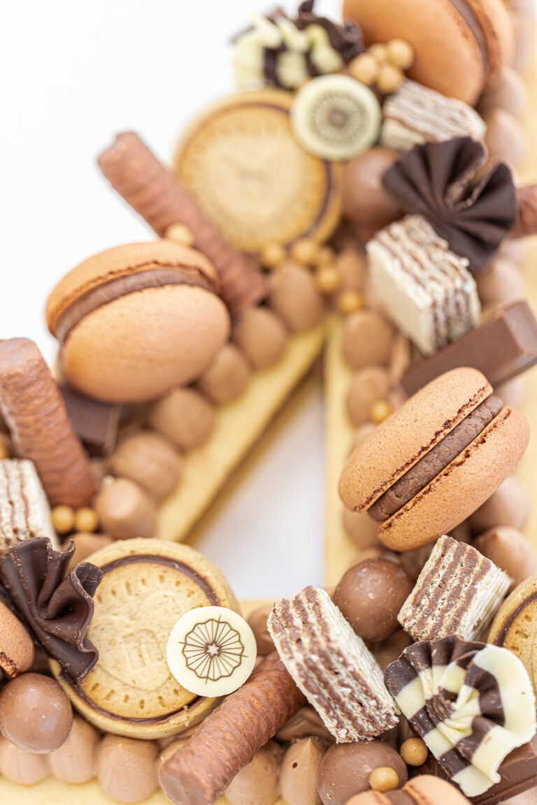 Détail d'un Number Cake chocolat décoré de macarons et gourmandises – Précieux Délices, pâtisserie sur mesure près d’Orléans